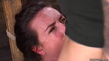 Brunette slave Casey Calvert in squat position with wrists and neck tied to wooden post gets deep throat fucked then rough pussy banged by big cock baldheaded master Derrick Pierce